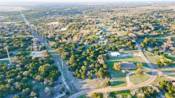 an aerial view of residential houses with outdoor space and trees