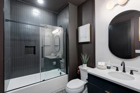 a bathroom with a sink a toilet and shower