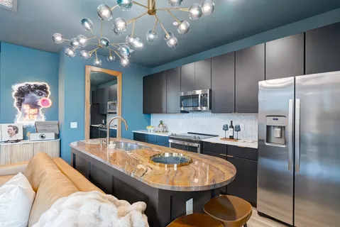 a large kitchen with kitchen island a chandelier and refrigerator