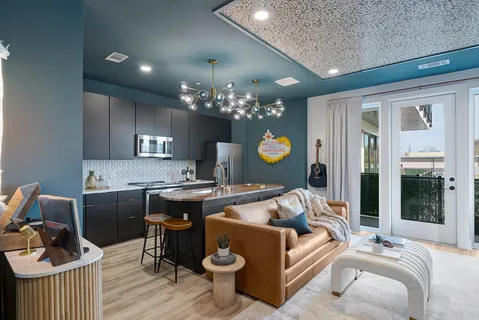 a living room with furniture a chandelier and kitchen view