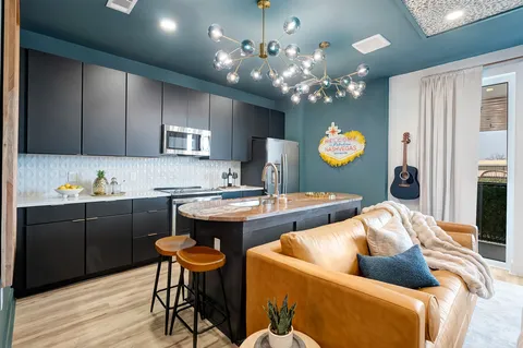 a kitchen with cabinets a sink and chairs