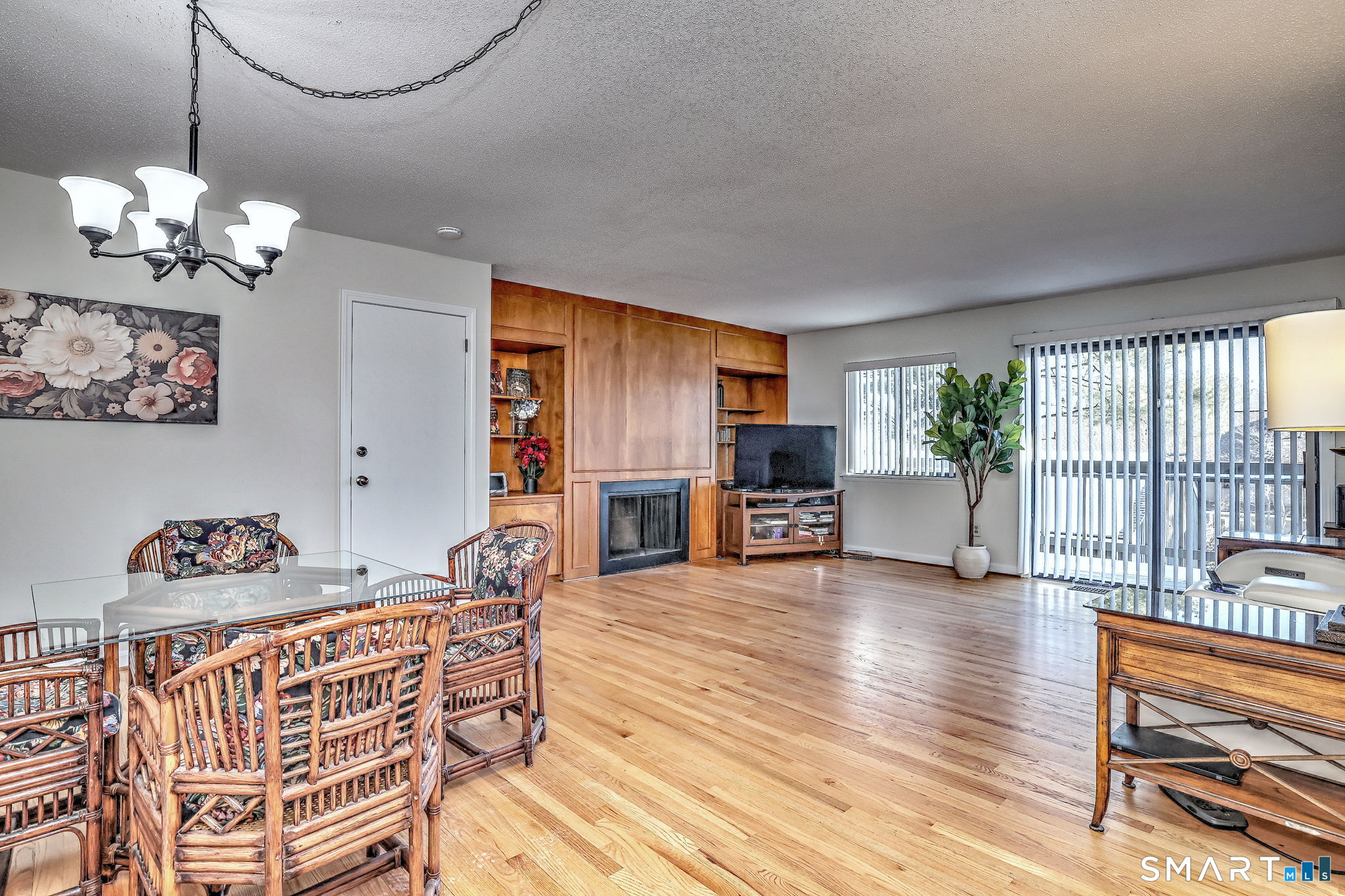 160 Brittany Farms Road, Unit D New Britain, CT 06053 - Photo 7 of 21 Spacious dining/living room area featuring hardwood floors, wood burning fireplace surrounded with shelves and sliders to deck.