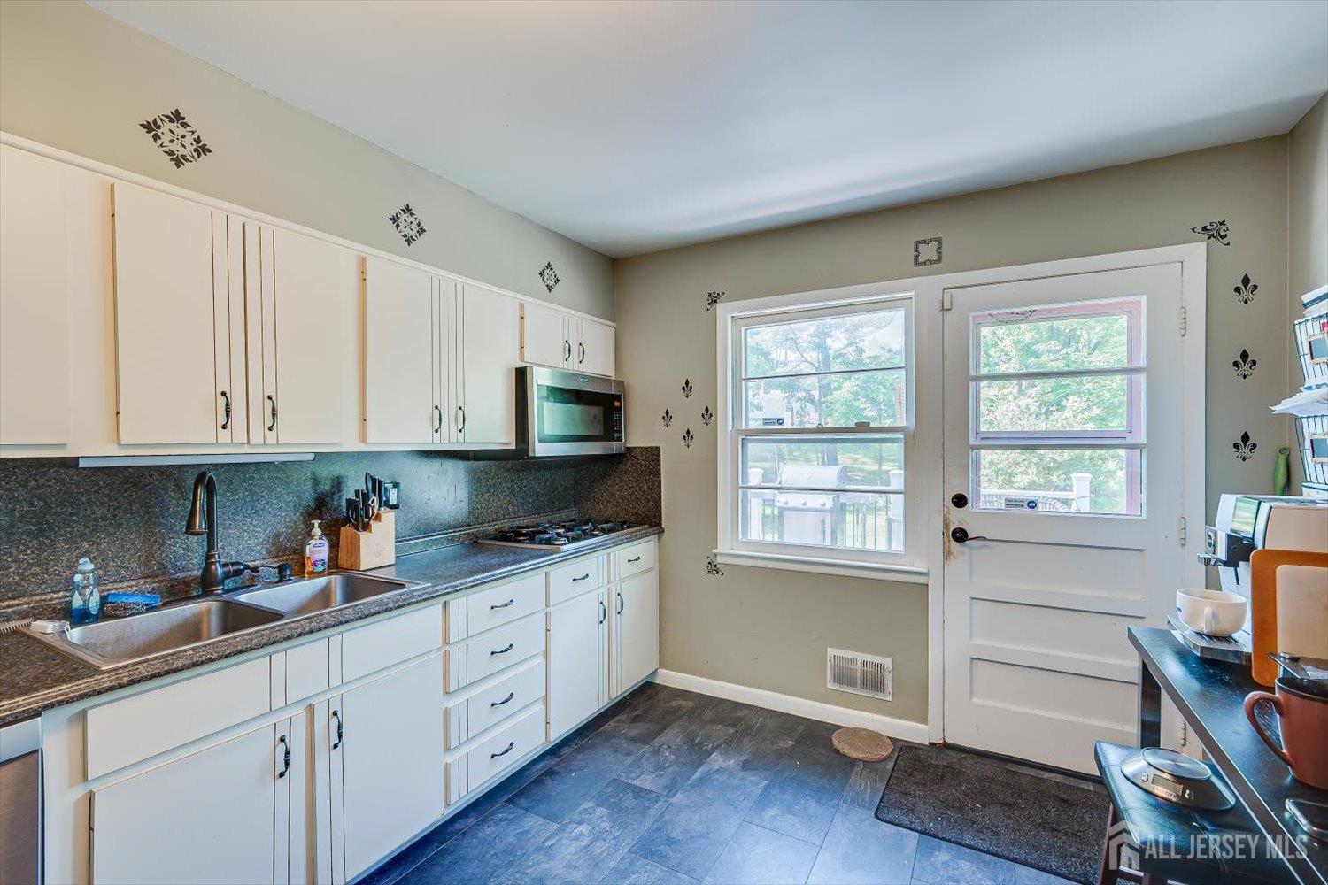 12 Gales Road Edison, NJ 08837 - Photo 12 of 35 a kitchen with stainless steel appliances white cabinets and a window