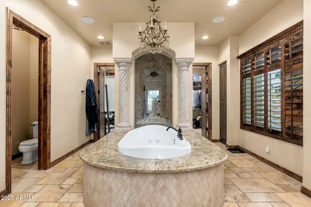 a bedroom with a large bed and a chandelier