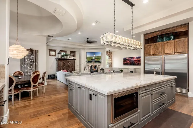 a kitchen with stainless steel appliances granite countertop a sink a washer and dryer with wooden cabinets