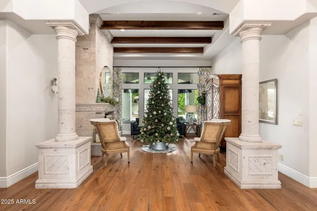 a living room with furniture a potted plant and a large window