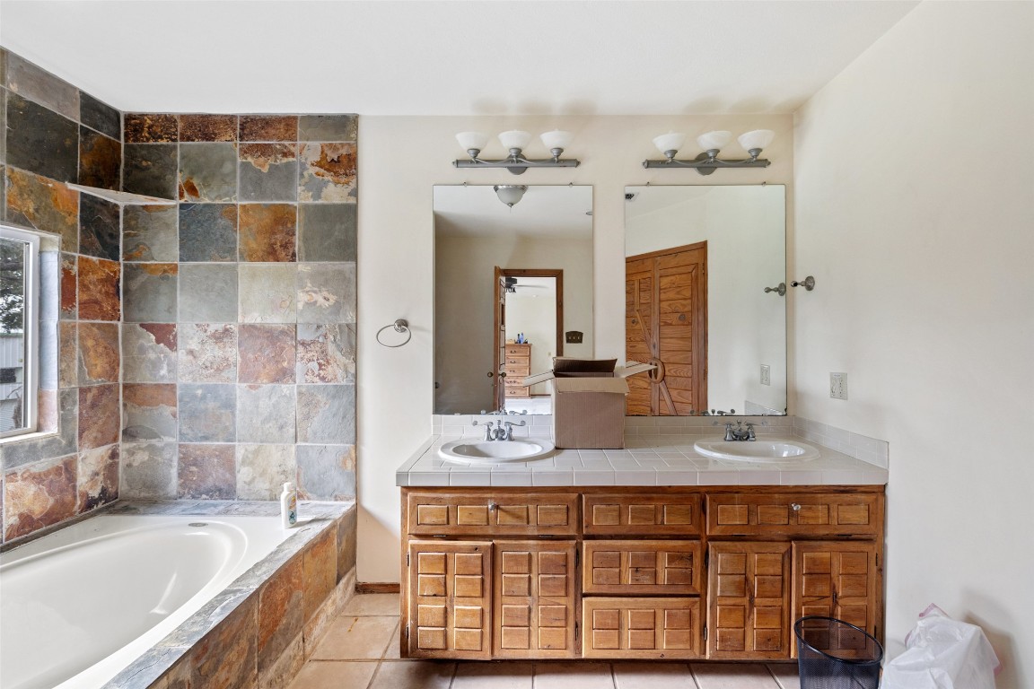 5731 Pool Canyon Cove Austin, TX 78734 - Photo 14 of 17 a bathroom with a bathtub sink and mirror