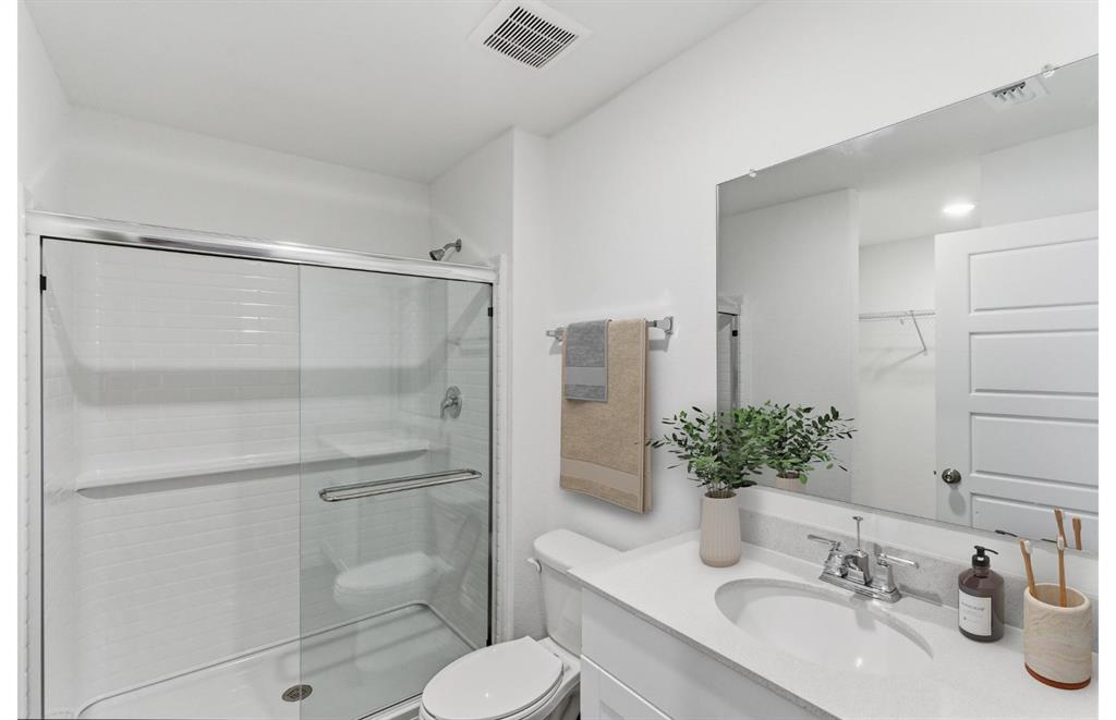 2534 Midfield Way Princeton, TX 75407 - Photo 11 of 14 a bathroom with a shower sink vanity mirror and toilet