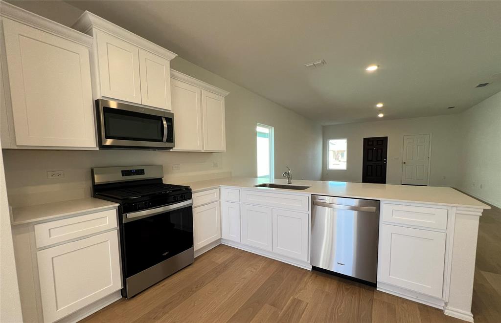 2534 Midfield Way Princeton, TX 75407 - Photo 3 of 14 a kitchen with stainless steel appliances a stove sink microwave and cabinets