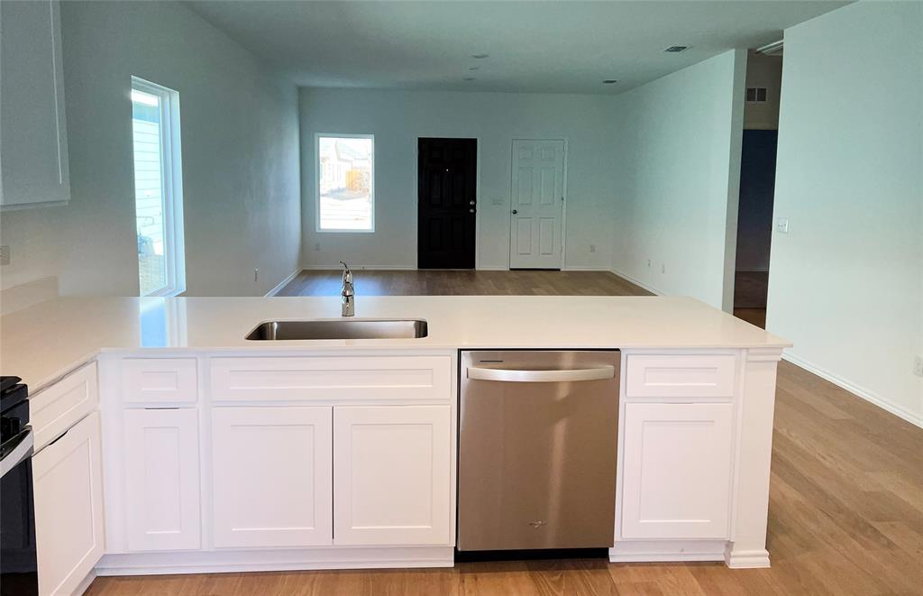 2534 Midfield Way Princeton, TX 75407 - Photo 4 of 14 a kitchen with white cabinets and sink