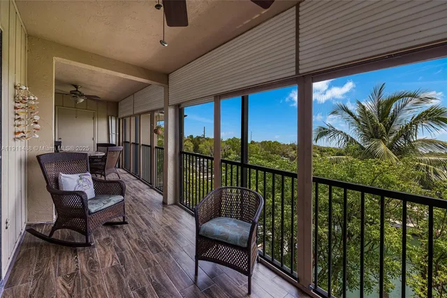 a view of a porch with furniture and wooden floor