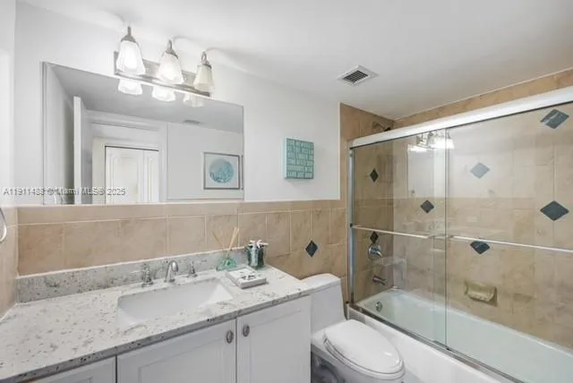 a bathroom with a granite countertop sink a toilet and shower