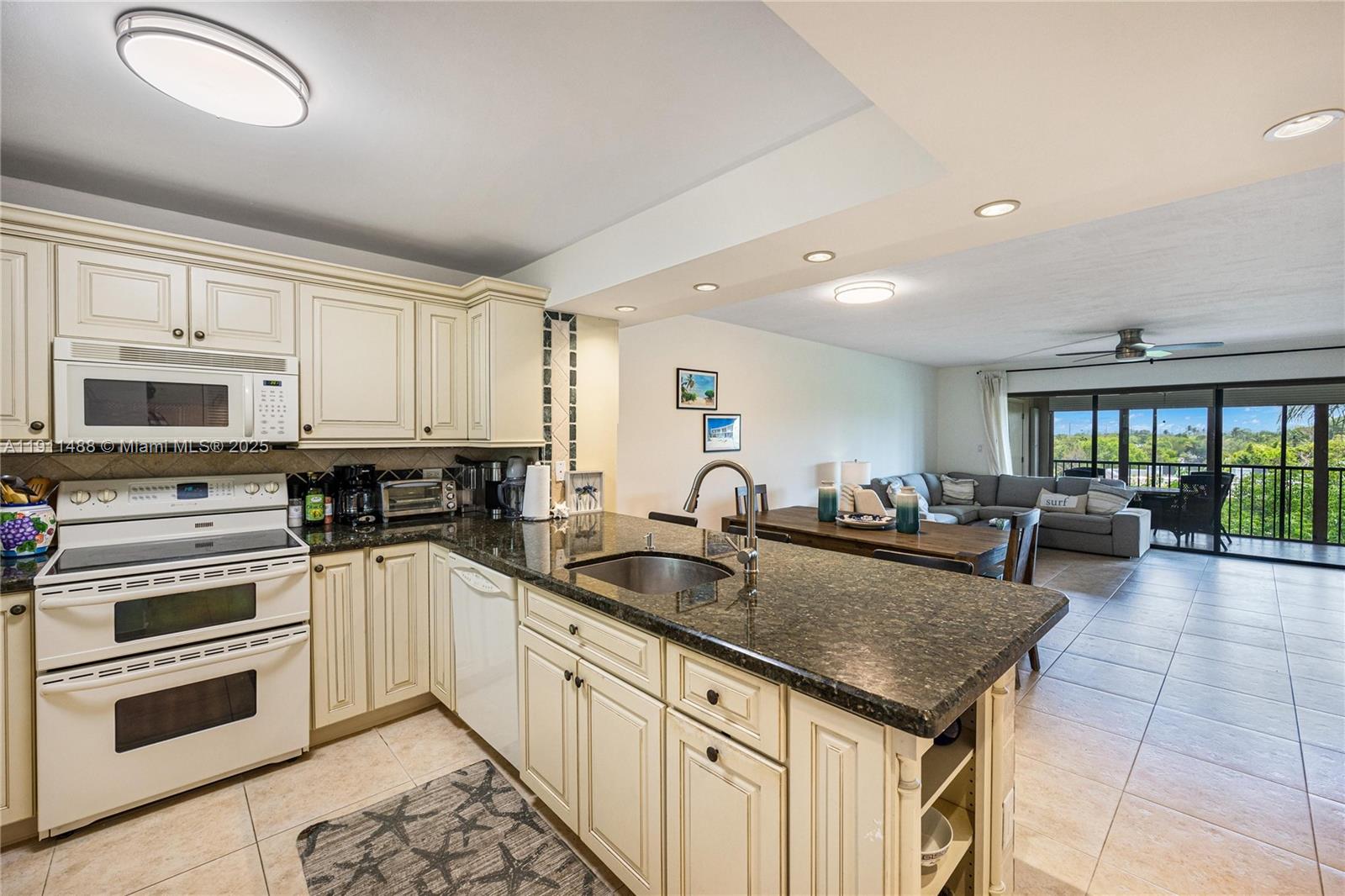96000 Overseas Highway, Unit W44 Key Largo, FL 33037 - Photo 6 of 33 a kitchen with granite countertop a sink and white cabinets