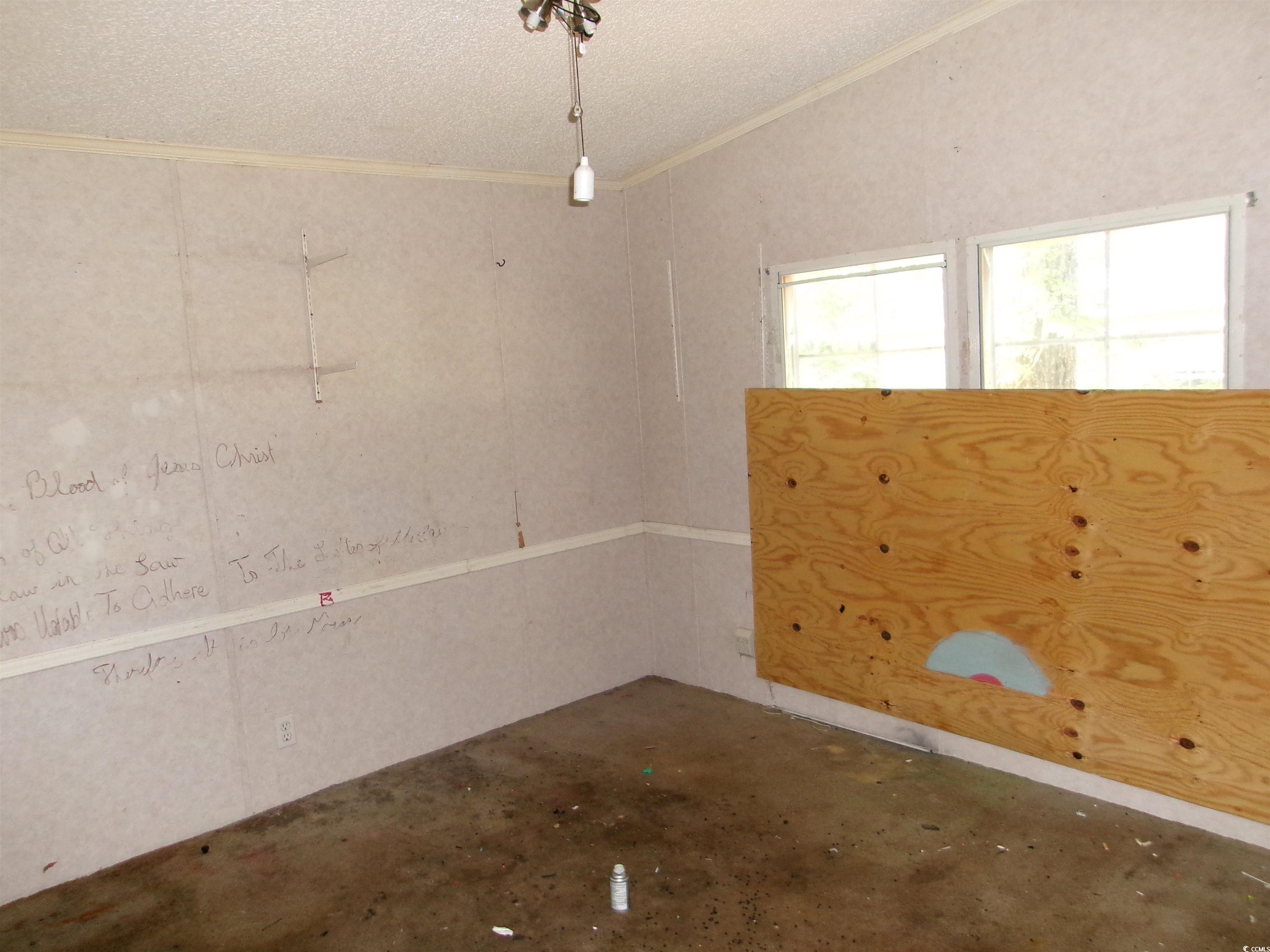 4261 Blake Road Myrtle Beach, SC 29588 - Photo 11 of 11 Spare room with ornamental molding, a textured ceiling, and concrete flooring