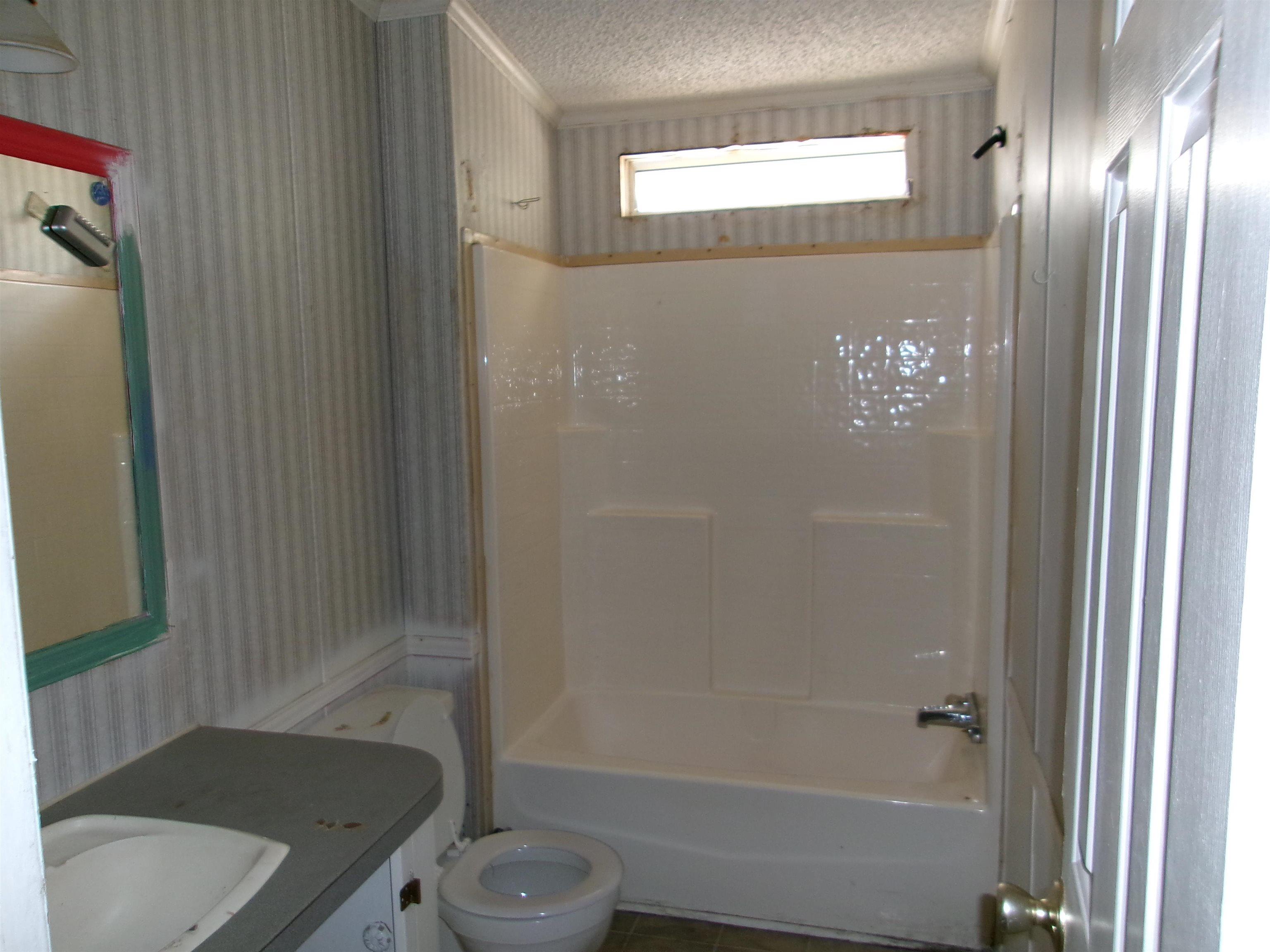 4261 Blake Road Myrtle Beach, SC 29588 - Photo 10 of 11 Bathroom featuring wallpapered walls, vanity, a textured ceiling, and shower / washtub combination