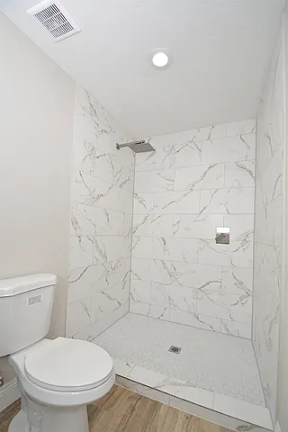 a bathroom with a toilet and a shower