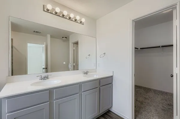 a bathroom with a double vanity sink and mirror