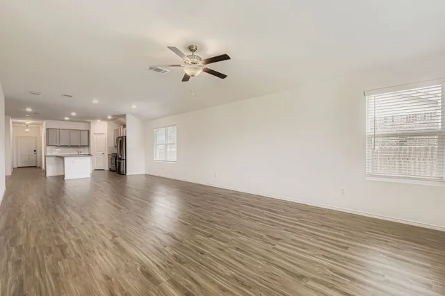 a view of empty room with wooden floor and windows