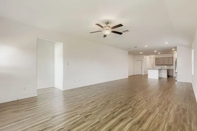 a view of empty room with wooden floor and window