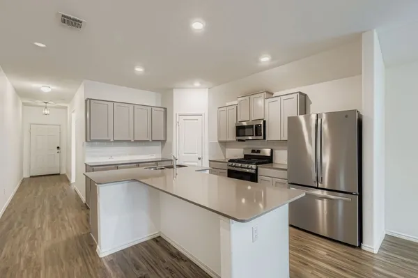a kitchen with a refrigerator a sink and cabinets