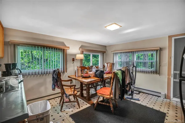a dining room with furniture and a floor to ceiling window