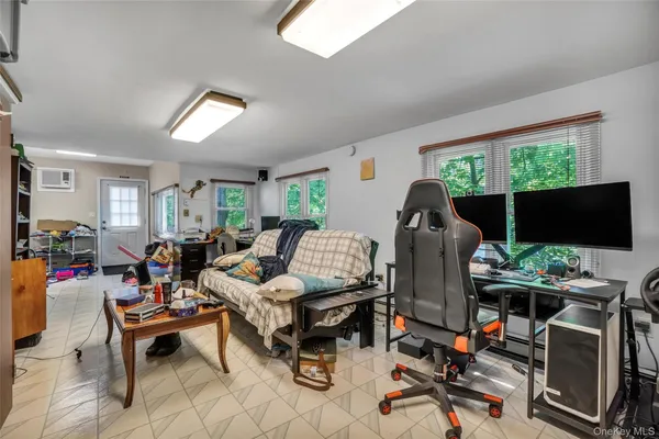 a living room with furniture a flat screen tv and a floor to ceiling window
