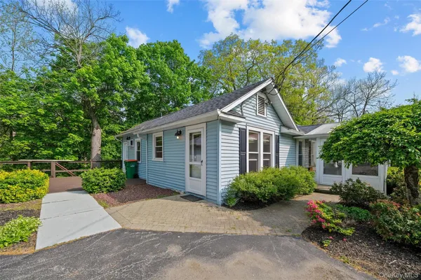 a front view of a house with a yard and trees