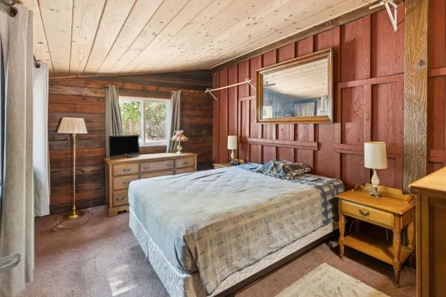 a bed sitting in a spacious bedroom next to a window