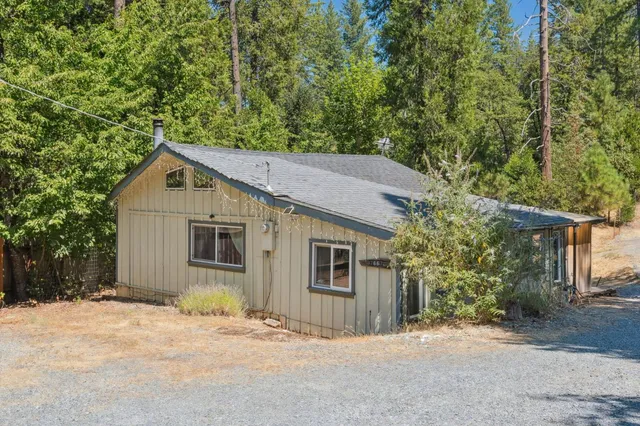 a view of a house with a yard and large tree