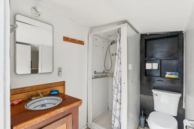 a bathroom with a sink a toilet and shower