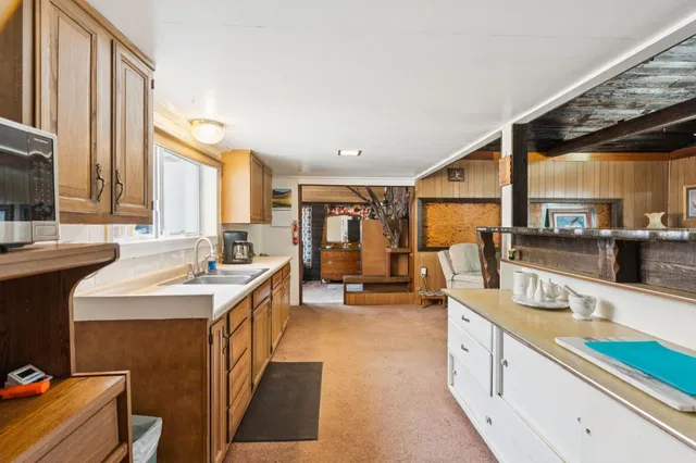 a kitchen with stainless steel appliances sink stove and large window