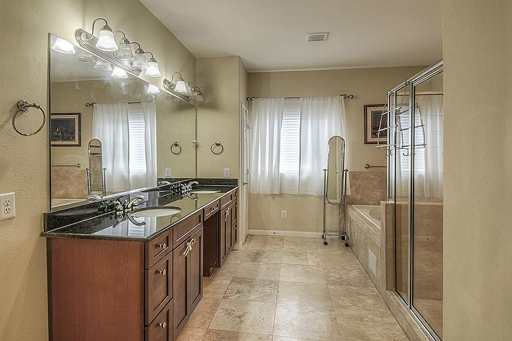1137 West 24th Street, Unit A Houston, TX 77008 - Photo 18 of 40 a bathroom with a granite countertop sink a large mirror and a shower