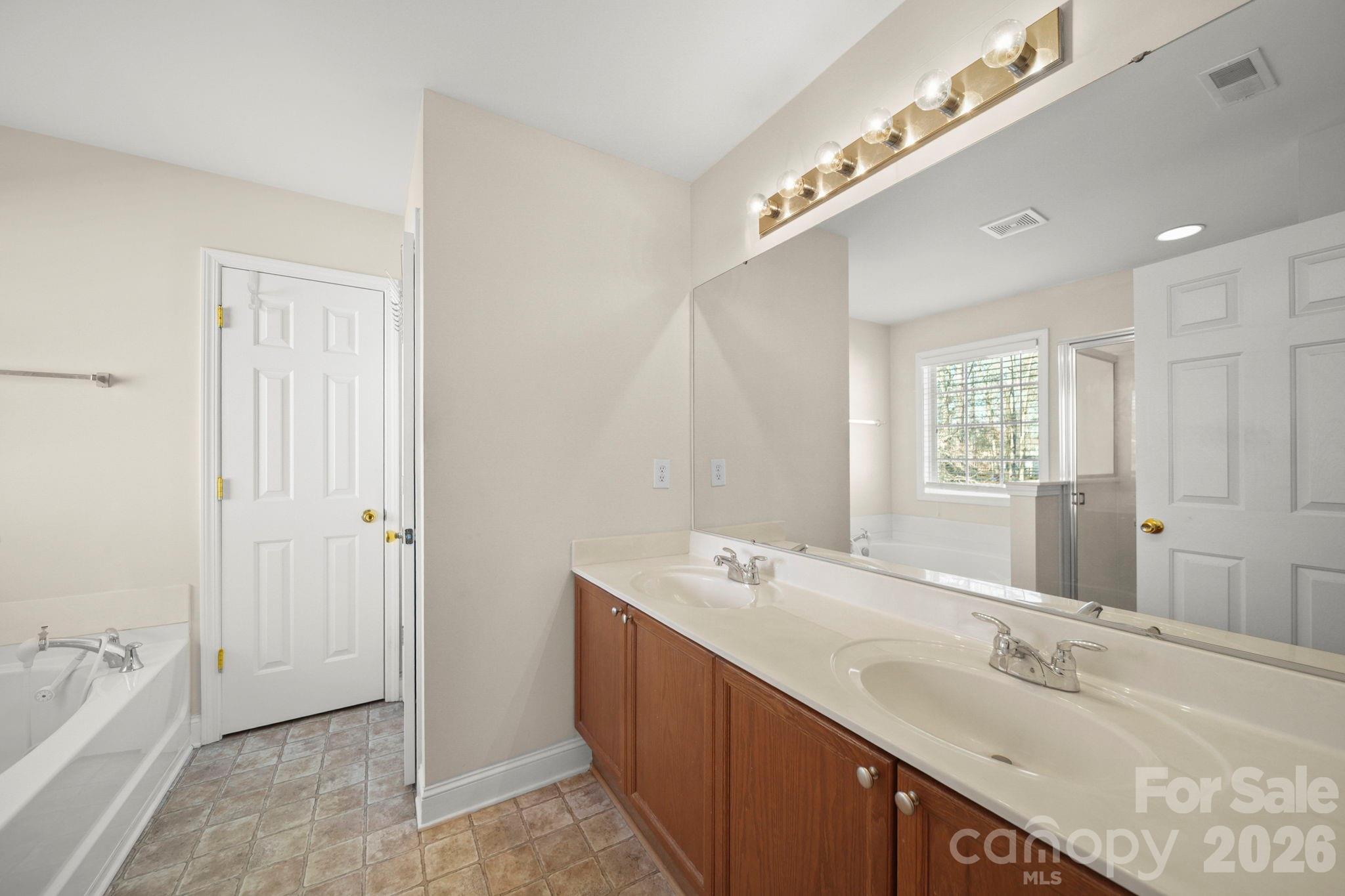 3035 Proverbs Court Monroe, NC 28110 - Photo 22 of 39 a spacious bathroom with a double vanity sink and mirror