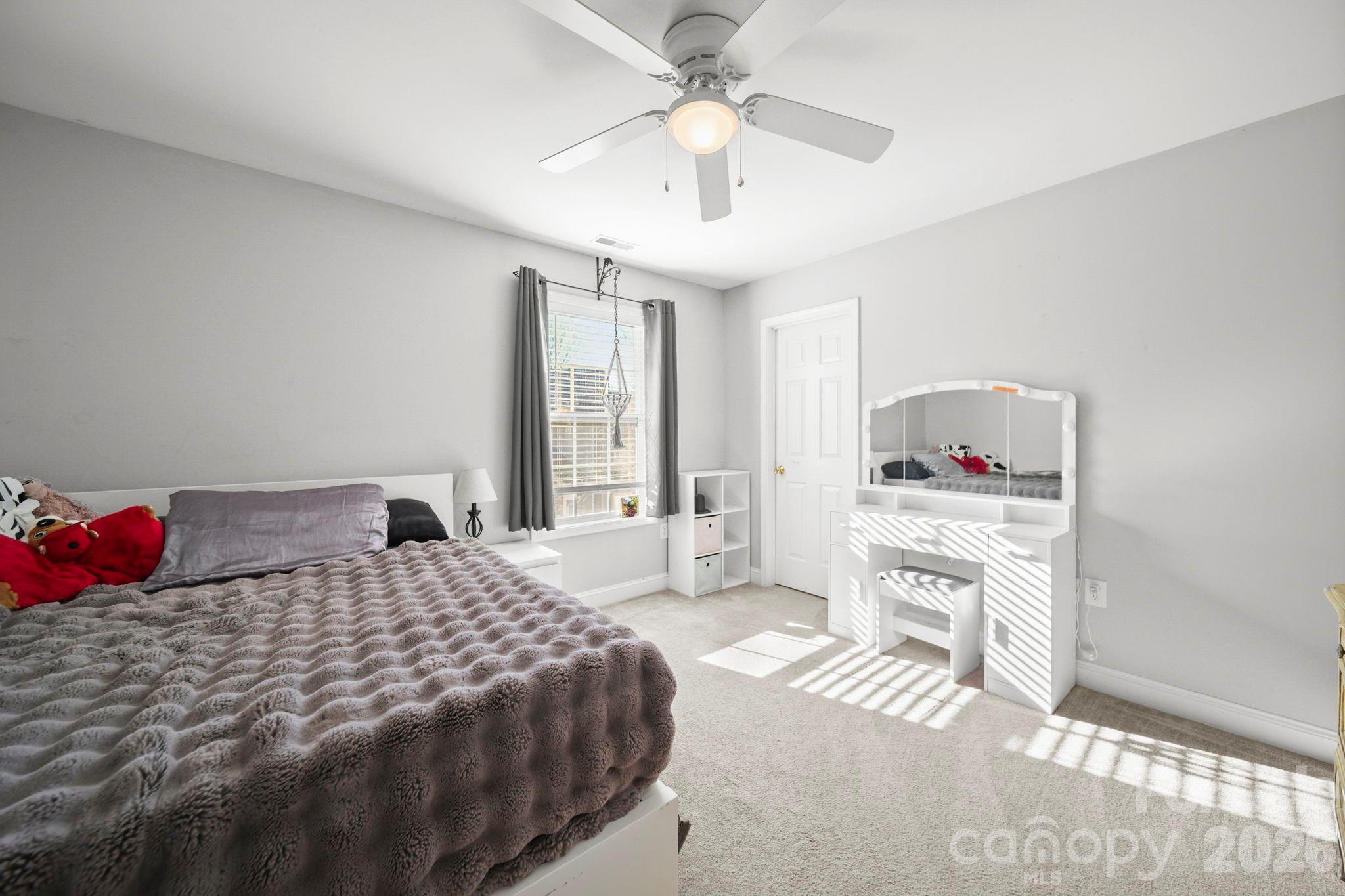 3035 Proverbs Court Monroe, NC 28110 - Photo 25 of 39 a bedroom with a bed and a chandelier