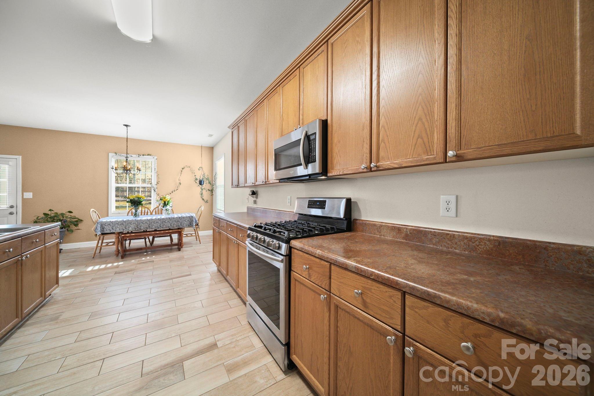 3035 Proverbs Court Monroe, NC 28110 - Photo 7 of 39 a kitchen with stainless steel appliances granite countertop a stove a sink and a microwave