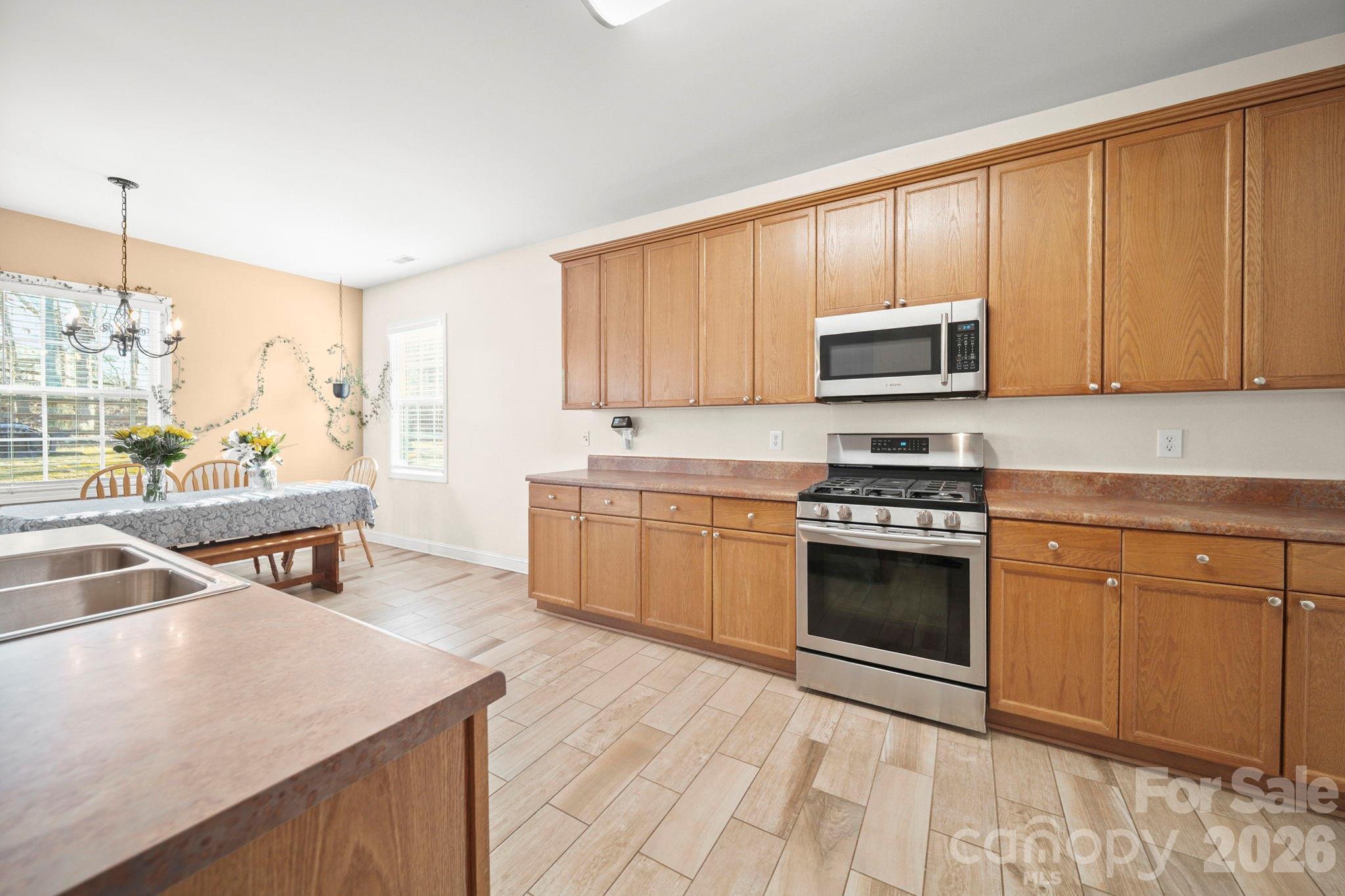 3035 Proverbs Court Monroe, NC 28110 - Photo 8 of 39 a kitchen with a stove a sink and a microwave