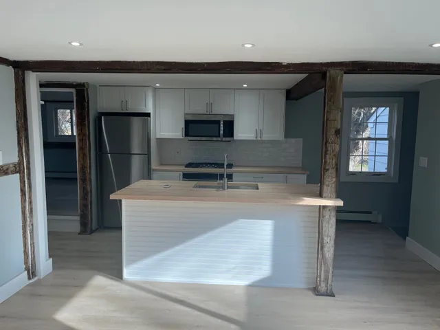 a kitchen with kitchen island a sink stainless steel appliances and cabinets