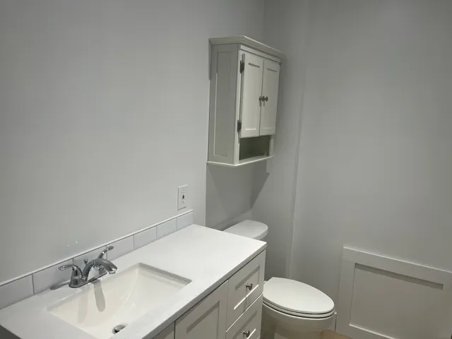 a bathroom with a sink a toilet and mirror