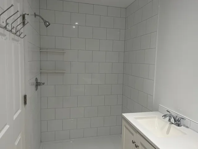 a bathroom with a sink shower and a mirror