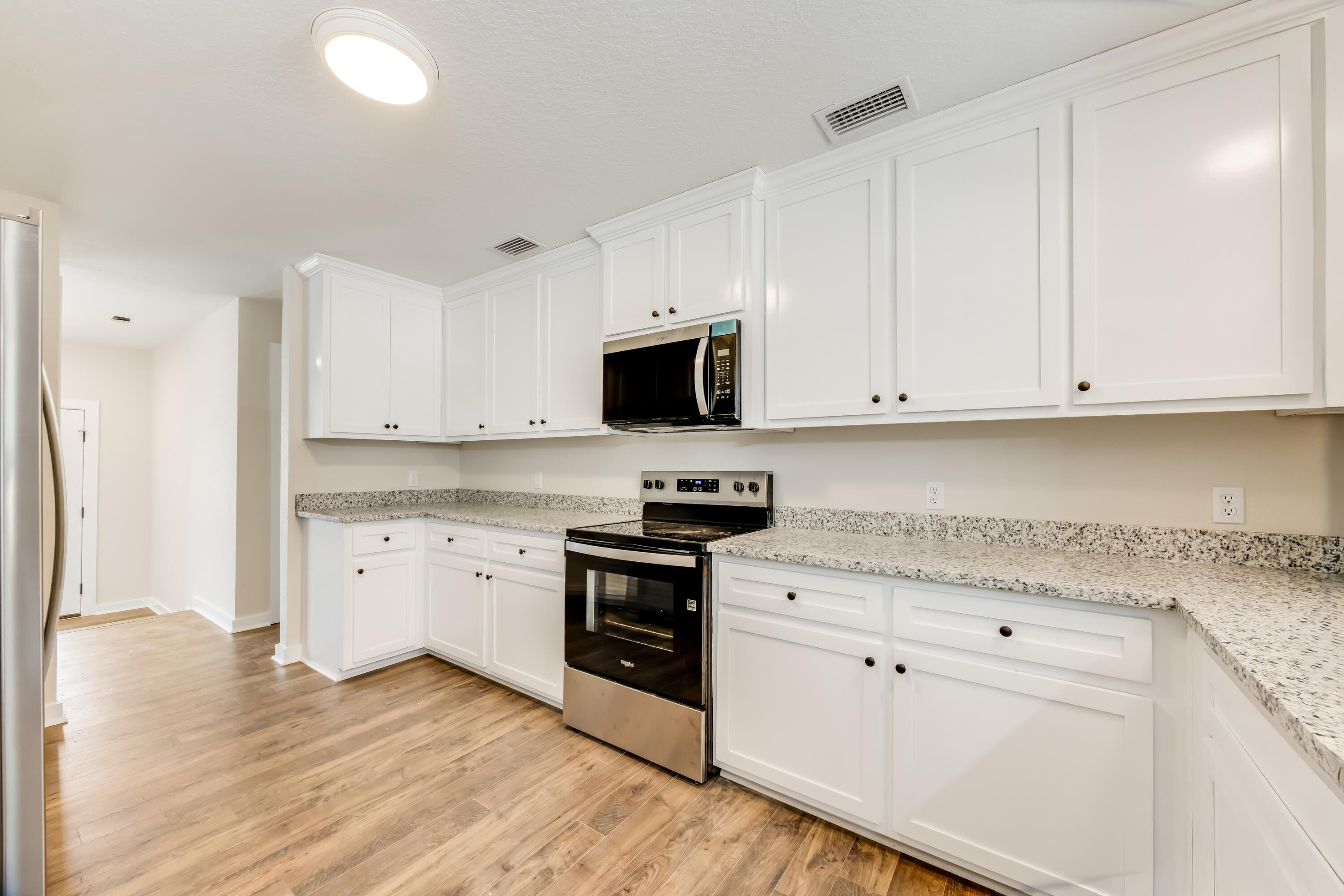 3005 Lillie Street Crestview, FL 32539 - Photo 11 of 46 a kitchen with granite countertop white cabinets and stainless steel appliances