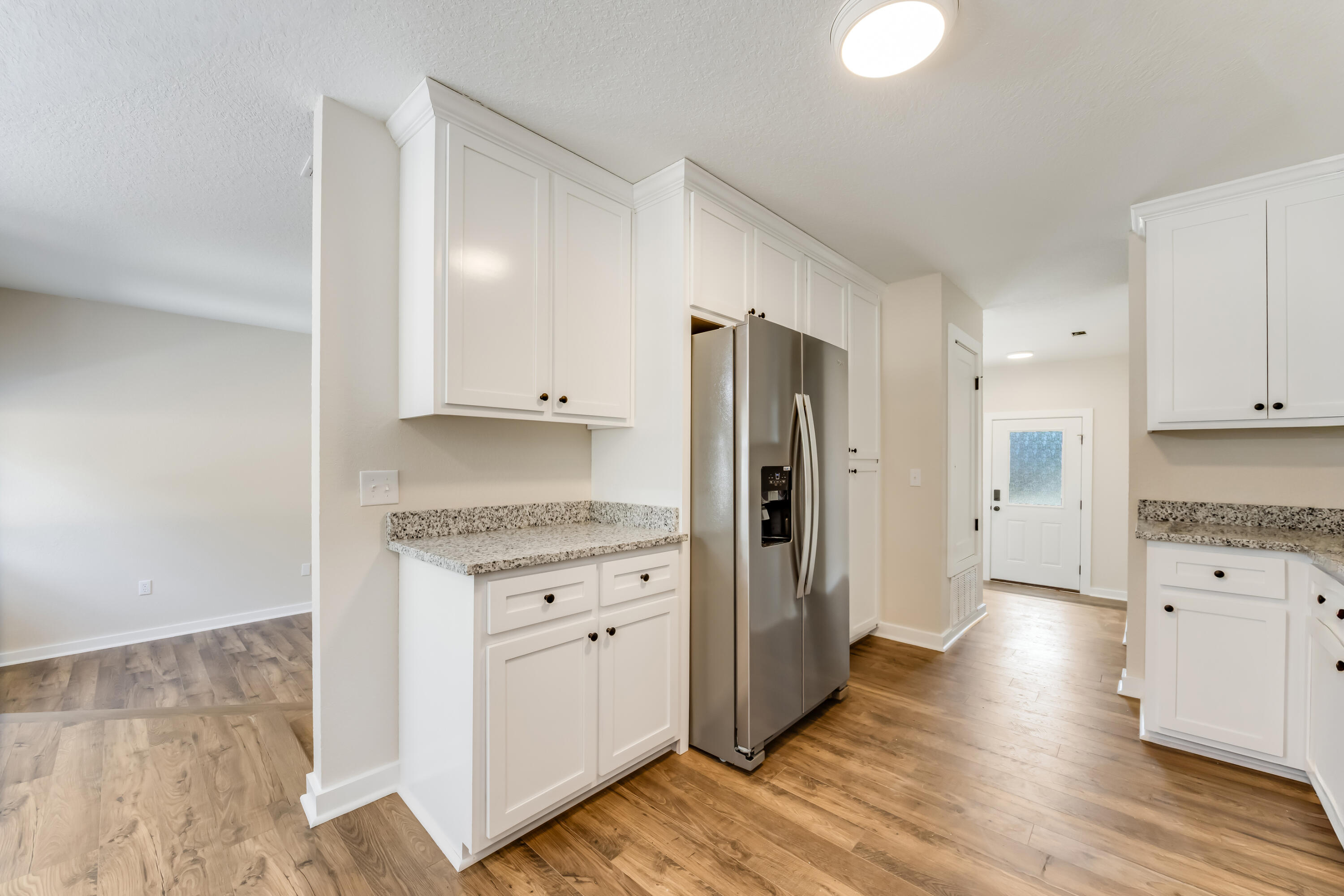 3005 Lillie Street Crestview, FL 32539 - Photo 13 of 46 a large kitchen with cabinets wooden floor and a refrigerator