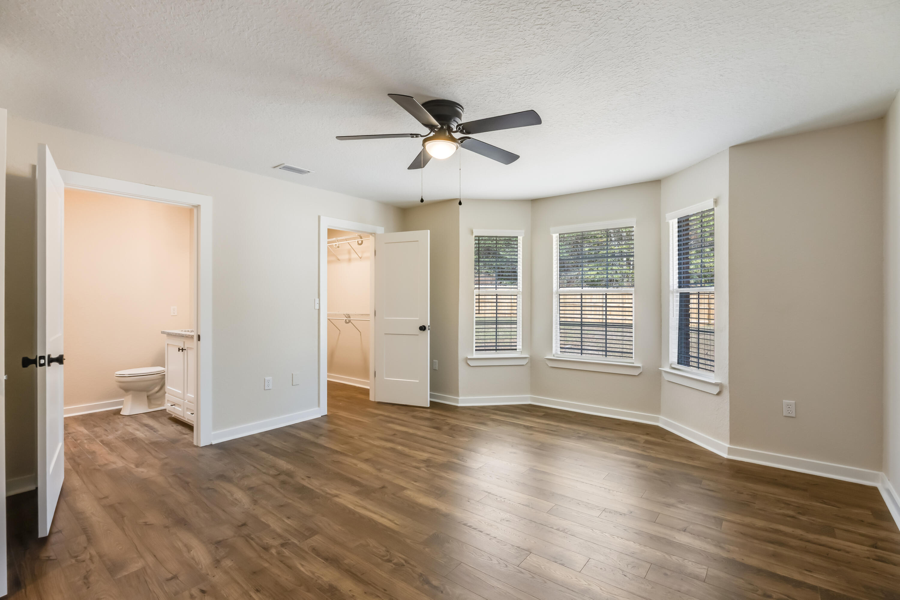 3005 Lillie Street Crestview, FL 32539 - Photo 19 of 46 a view of an empty room with a window and wooden floor