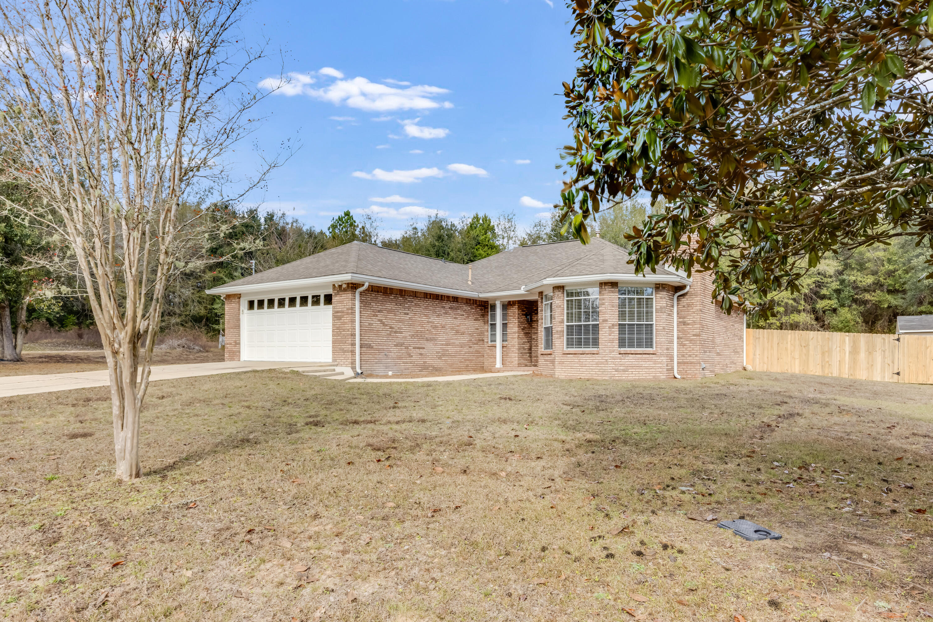 3005 Lillie Street Crestview, FL 32539 - Photo 2 of 46 a front view of a house with a yard and garage