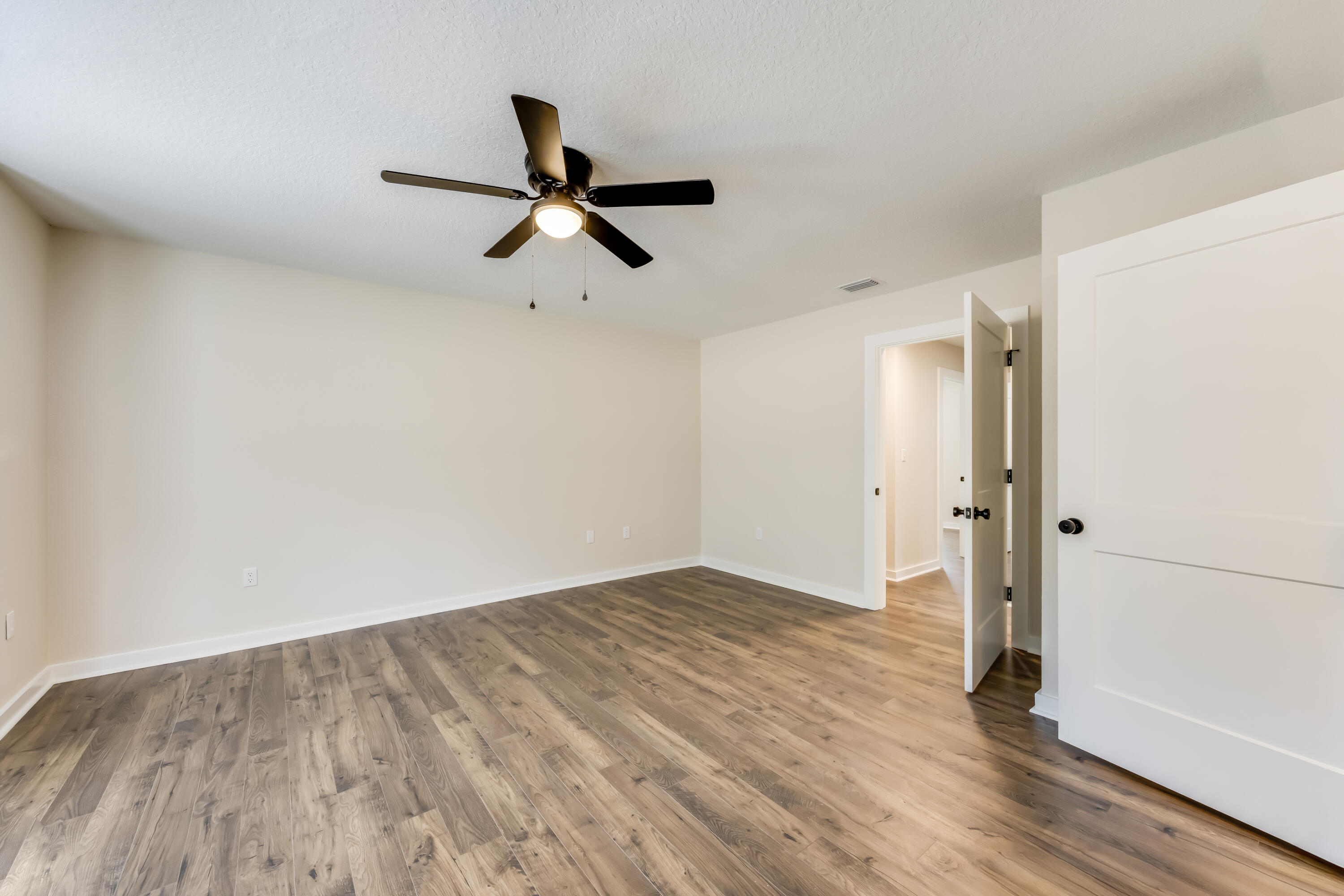 3005 Lillie Street Crestview, FL 32539 - Photo 21 of 46 an empty room with wooden floor and windows