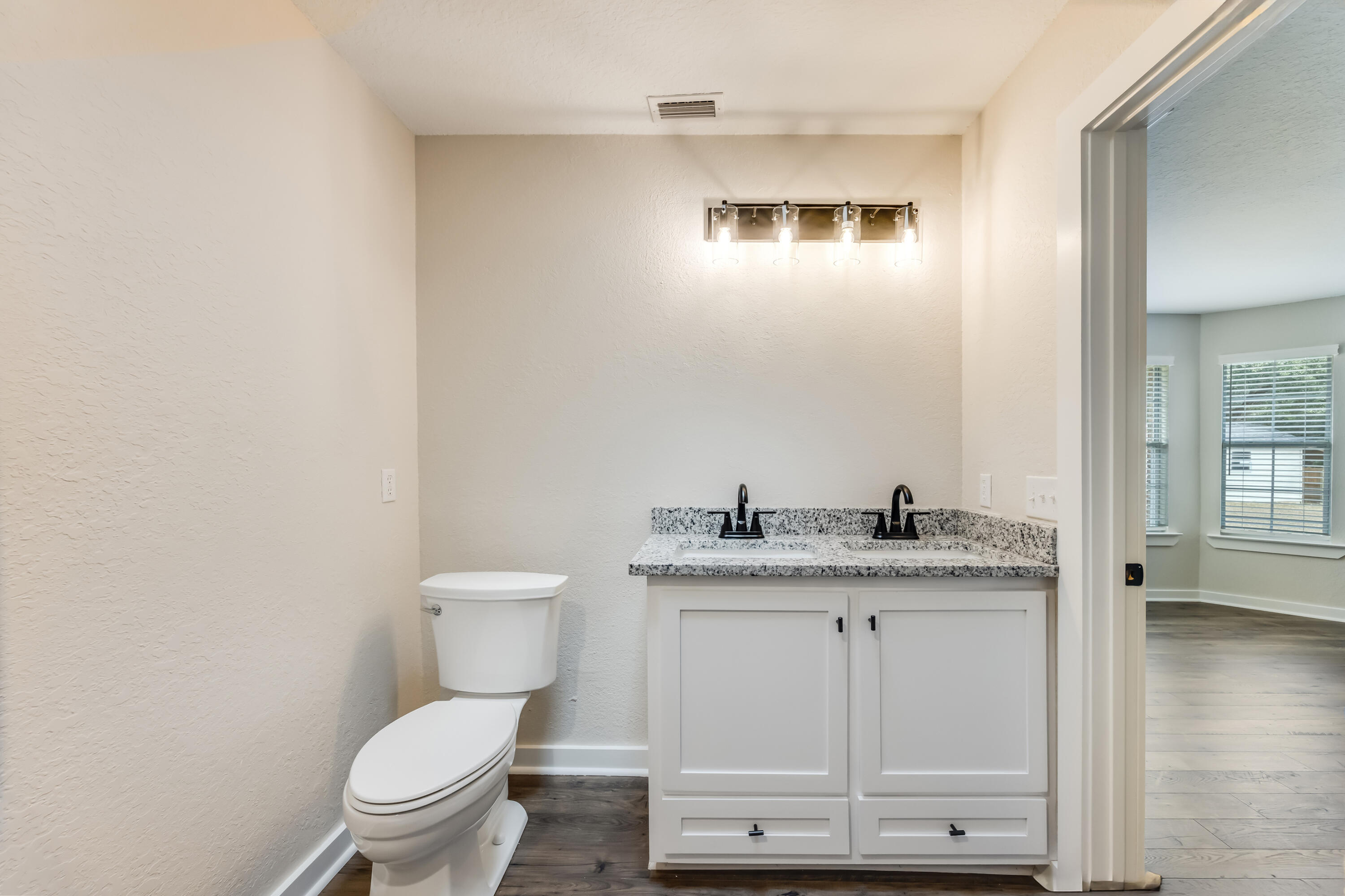 3005 Lillie Street Crestview, FL 32539 - Photo 22 of 46 a bathroom with a granite countertop sink a toilet and a mirror