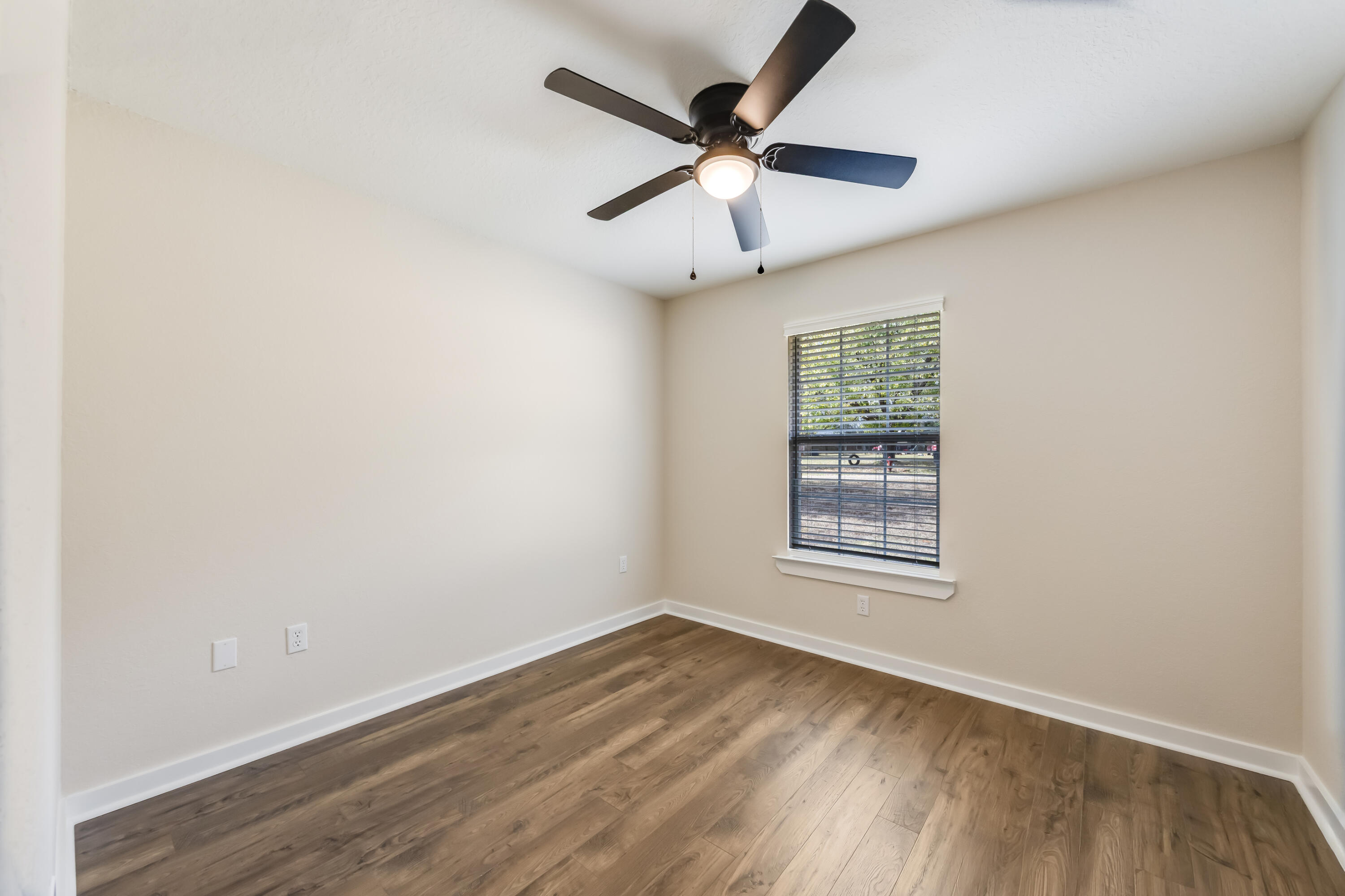 3005 Lillie Street Crestview, FL 32539 - Photo 27 of 46 an empty room with wooden floor ceiling fan and windows