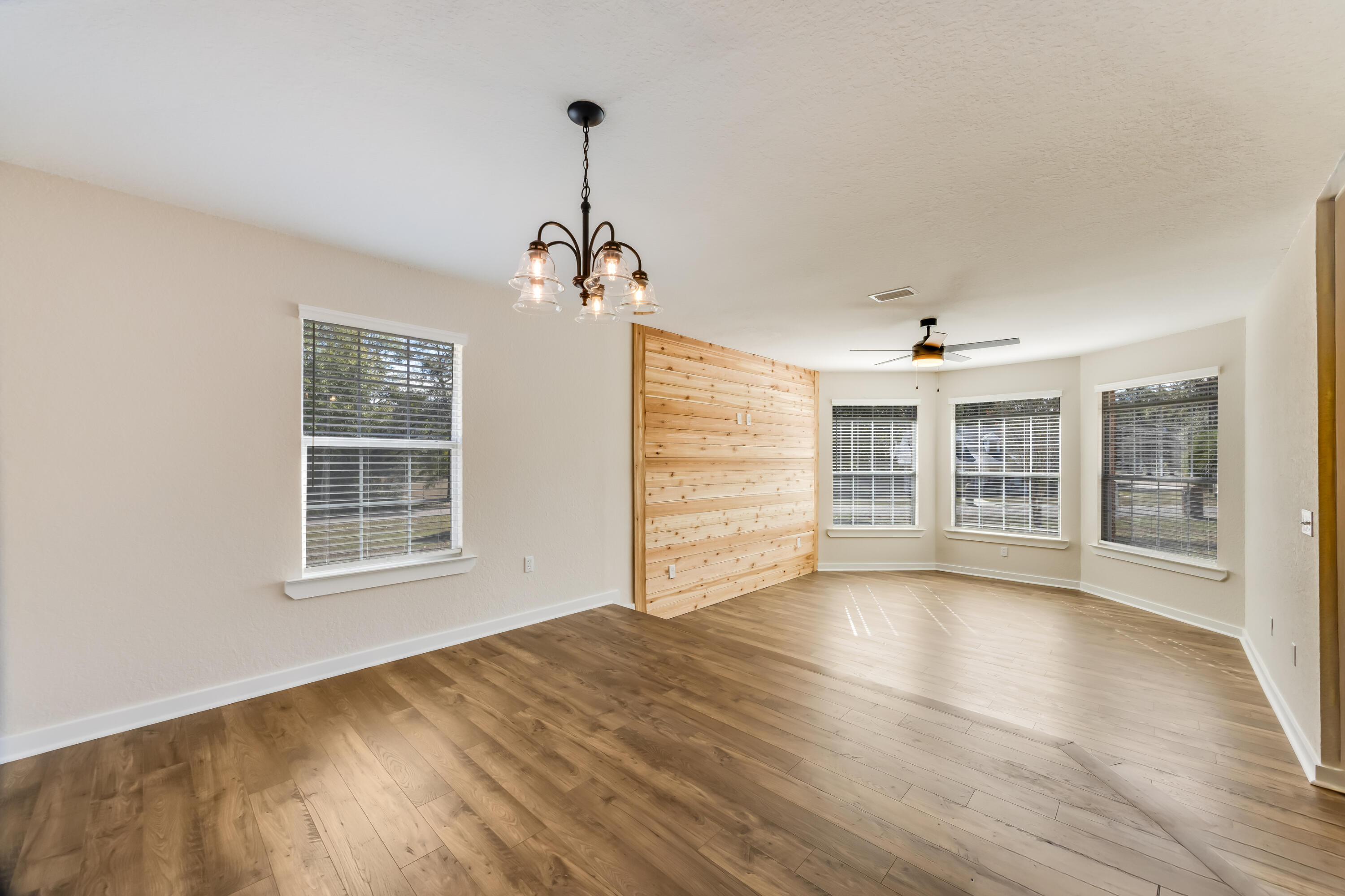 3005 Lillie Street Crestview, FL 32539 - Photo 6 of 46 a view of an empty room with a window and wooden floor