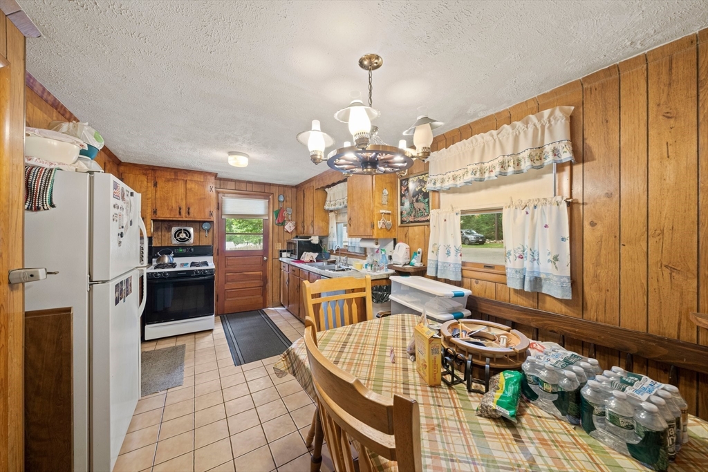 4 Lakeview Road Foxboro, MA 02035 - Photo 11 of 32 a kitchen with a refrigerator a stove top oven a dining table and chairs