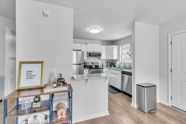 a kitchen with cabinets and wooden floor