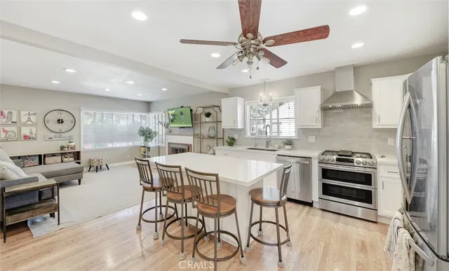 a kitchen with stainless steel appliances kitchen island a table and chairs in it